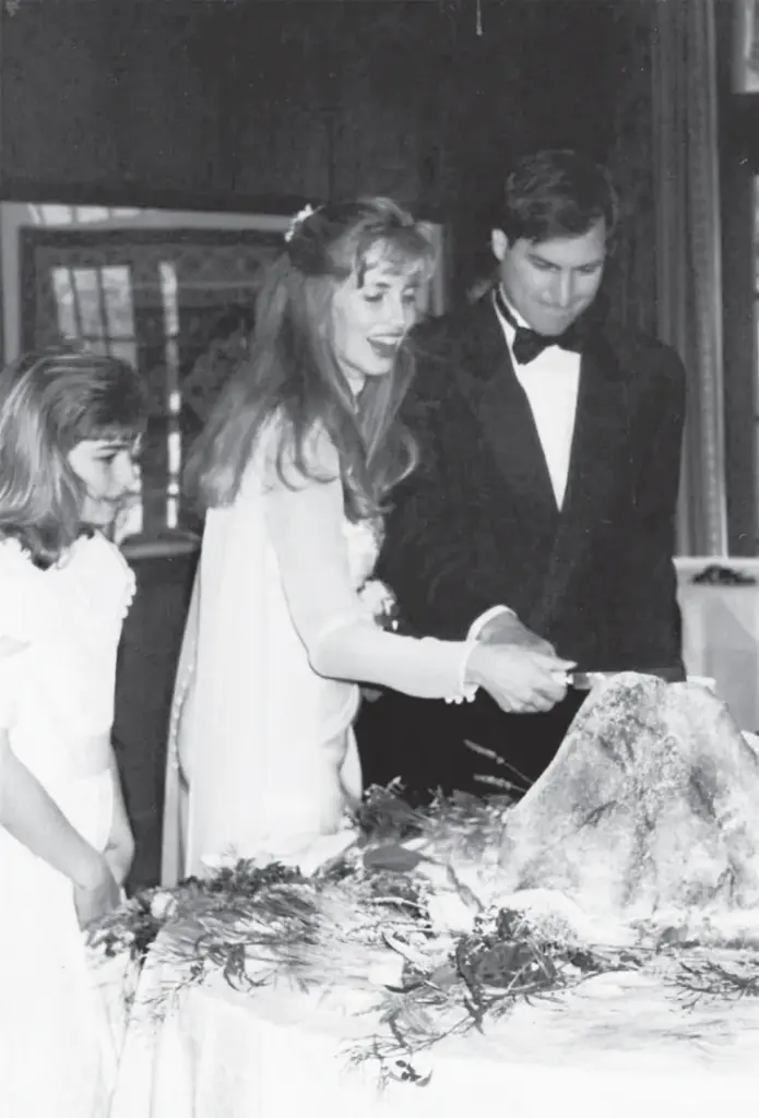 Cutting  the  cake  in  the  shape  of  Half  Dome  with  Laurene  and  his  daughter  from  a  previous